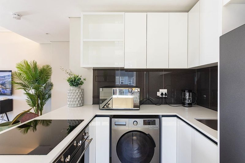 The kitchen at Two Twenty Loop, with the washer and dryer